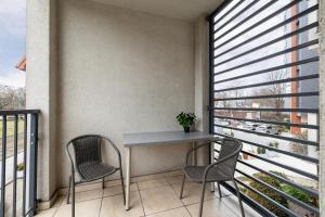 a balcony with a table and two chairs at Luxury Apartment with Balcony & Parking Cracow by Renters Prestige in Krakow