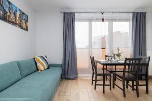 a living room with a blue couch and a table at Luxury Apartment with Balcony & Parking Cracow by Renters Prestige in Krakow