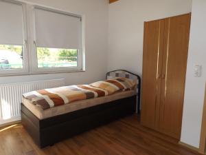 Schlafzimmer mit einem Bett und einem Fenster in der Unterkunft Pension Rego in Pirna
