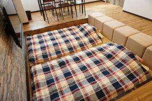 a living room with a couch with a blanket on it at YOUR ROOM Kyomachi Vacation STAY 1321 in Kumamoto