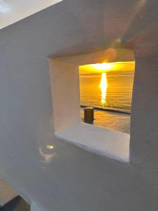 vistas a una puesta de sol a través de una pared blanca en Hotel CASA VICO, en Ako