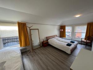 een slaapkamer met 2 bedden en een spiegel bij Appartement met prachtig uitzicht over de binnenstad van Leeuwarden in Leeuwarden