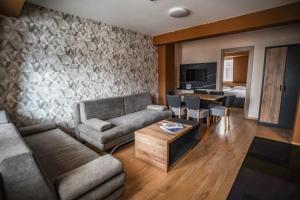 a living room with a couch and a table at Apartments and rooms Max-Well in Jahorina