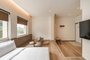 a bedroom with a bed and a large window at 河映宿沐 River Trees Hotel in Kaohsiung