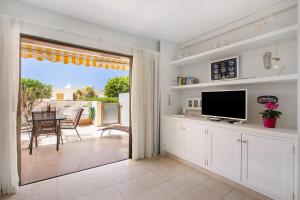 a living room with a television and a dining room with a table at Apartamento cerca de la playa in Santiago del Teide