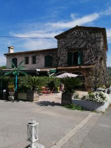 ein Steingebäude mit einem Tisch und Stühlen davor in der Unterkunft Auberge les Aromes in Grasse