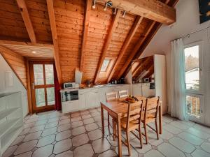 eine Küche mit Holzdecken sowie einem Holztisch und Stühlen in der Unterkunft Dachwohnung in Flughafennähe in Kloten