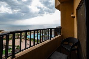 a balcony with a view of the beach and the ocean at East hotel in Sowayma