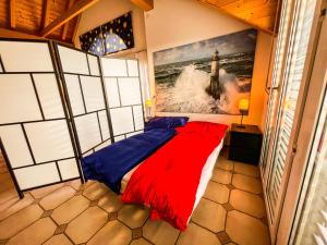 ein Schlafzimmer mit einem Bett mit einem großen Gemälde an der Wand in der Unterkunft Dachwohnung in Flughafennähe in Kloten