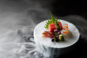 a white plate with food on top of smoke at Shoraiso in Yamanouchi