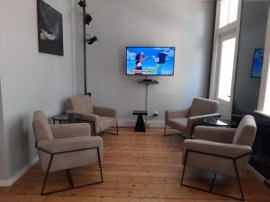 a waiting room with chairs and a flat screen tv at Daddy Long Legs Art Hotel in Cape Town