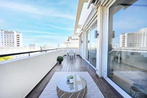 a balcony with a table and a view of the city at 3BR Penthouse at Hilton Beach by HolyGuest in Tel Aviv