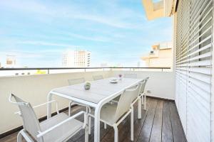 - Balcón con mesa blanca y sillas en 3BR Penthouse at Hilton Beach by HolyGuest en Tel Aviv
