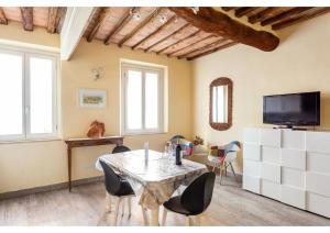 ein Wohnzimmer mit einem Tisch und Stühlen sowie einem TV in der Unterkunft 106 Lodge in Siena