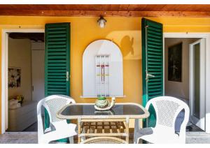 einen Tisch und Stühle auf einer Terrasse mit grünen Rollläden in der Unterkunft 106 Lodge in Siena