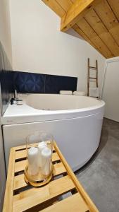 a bathroom with a tub and a table with candles at Le Bon'abry #Balnéo#Terrasse#Garage in Orcines +9 photos