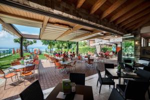 a restaurant with tables and chairs and people sitting at tables at Villa Gasparina in Ronchi