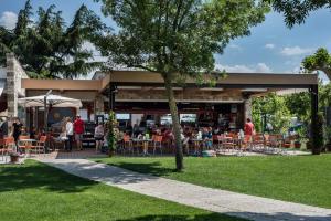 a restaurant with people sitting at tables in a park at Villa Gasparina in Ronchi