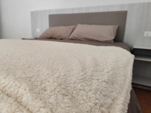una manta blanca en una cama en un dormitorio en Casa lago di lesina, en Lesina