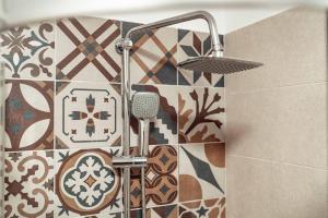 um chuveiro na casa de banho com uma parede de azulejos em Luxury Collection Studios at Q Residence Palas Mall em Iaşi