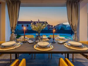 ein Esstisch mit Blick auf einen Pool in der Unterkunft Brand new Villa 'Maslina' with Pool in Povljana