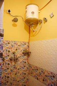 a bathroom with a shower with a bucket on the wall at Malti Home stay 5 minute walking distance fromAyodhya DhamRailway Station in Ayodhya +8 photos