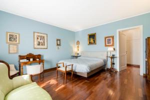 1 dormitorio con paredes azules, 1 cama y 1 sofá en Villa Le Fontanelle In Forte Dei Marmi With Ac en Forte dei Marmi