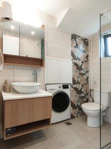 uma casa de banho com um lavatório e uma máquina de lavar roupa em Cream Cozy Getaway - 3 Pearls Pool Retreat em Dhémbla