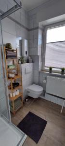 a bathroom with a white toilet and a window at Ferienwohnungen Op der Kees in Irsch