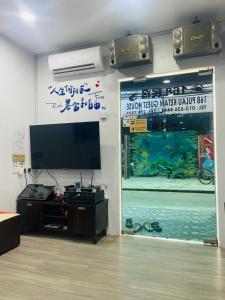 um quarto com uma televisão de ecrã plano e um aquário em 吉胆168民宿 168PulauKetam GuestHouse em Bagan Teochew