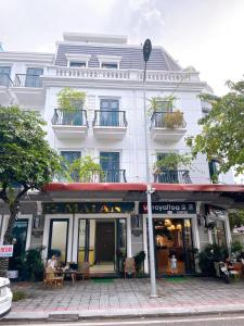 a large white building with a store in front of it at Mai An Homestays in Móng Cái