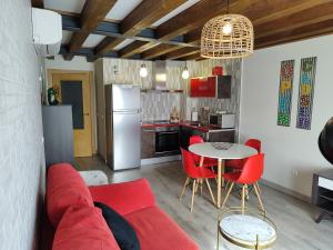 een woonkamer met een rode bank en een tafel bij Apartamentos La Alborada Medieval in Ayllón