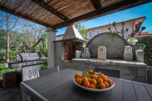 un tazón de naranjas sentado en una mesa en un patio en Villa Le Fontanelle In Forte Dei Marmi With Ac en Forte dei Marmi