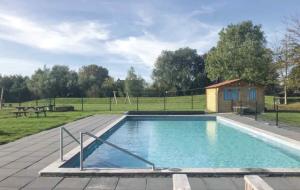 a swimming pool in a field with a fence at De Fjoertoer in Tzummarum
