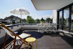 a patio with a table and chairs and an umbrella at Luxusappartement Hochries - 106qm mit sonniger Dachterrasse in Bad Aibling