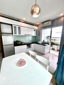 cocina con mesa blanca y armarios blancos en MY DREAM APARTMENT _ HON CHONG BEACH, en Nha Trang