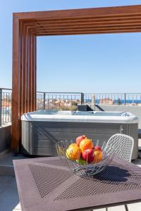 a bowl of fruit on a table on a balcony at Anele Luxury Suites in Chania Town