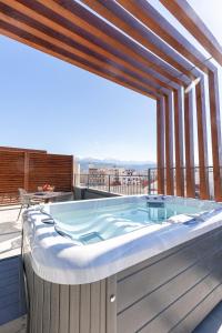 a hot tub on a balcony with a view at Anele Luxury Suites in Chania Town