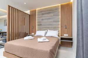 a bedroom with a bed with two towels on it at Anele Luxury Suites in Chania Town