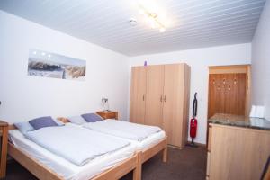 Schlafzimmer mit einem Bett und einem Holzschrank in der Unterkunft Haus Ufen - In den Dünen 18c in Norderney