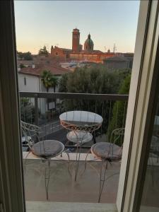 Habitación con vistas a un balcón con sillas y mesa. en Vista Duomo Ravenna Apartment, en Rávena