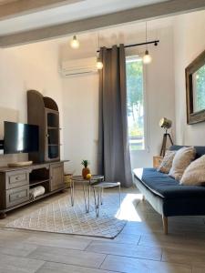 un salon avec un canapé bleu et une télévision dans l'établissement Villa Maya - 4 Amellau - AVIGNON - CLIM - WIFI, à Avignon