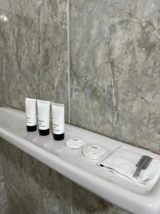 a bathroom sink with three cups and a mirror at Pearl Resort Panglao,Dauis Bikini Beach in Dauis +120 photos