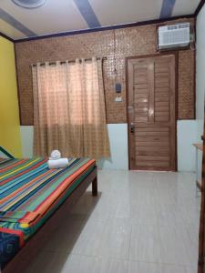 a bedroom with a bed and a wooden door at ALFA Garden Lodge in El Nido