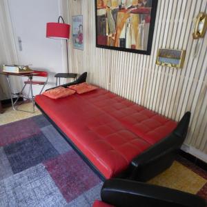 een rood bed in een kamer met een tafel en stoelen bij Vintage in Perpignan in Perpignan