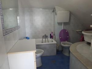 a bathroom with a tub and a toilet and a sink at Monolocale nonna Elena in Procida