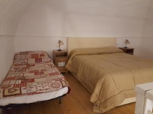 Monolocale nonna Elena في بروسيدا: غرفة نوم بسريرين ومصبين على الطاولات