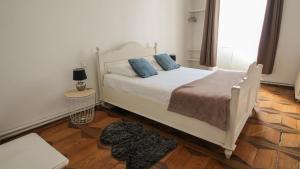 una camera da letto con un letto bianco con cuscini blu di Residence Pasteur Angouleme ad Angoulême