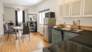 a kitchen with a stainless steel refrigerator and a table at Residence Pasteur Angouleme in Angoulême