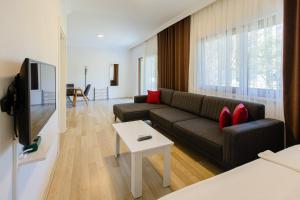a living room with a couch and a table at Keyif Pension & Aparts in Cıralı